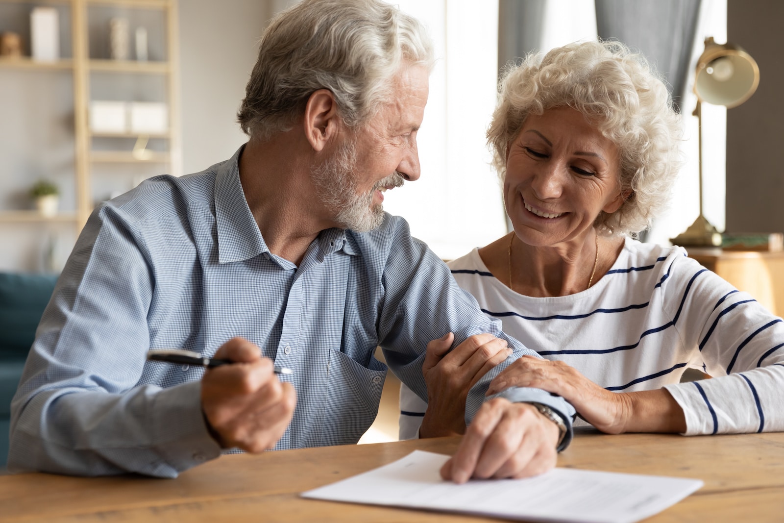 Older couple discuss agreement ready to sign contract
