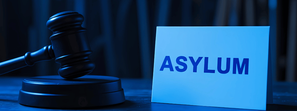 A legal gavel and a sign that says “Asylum”