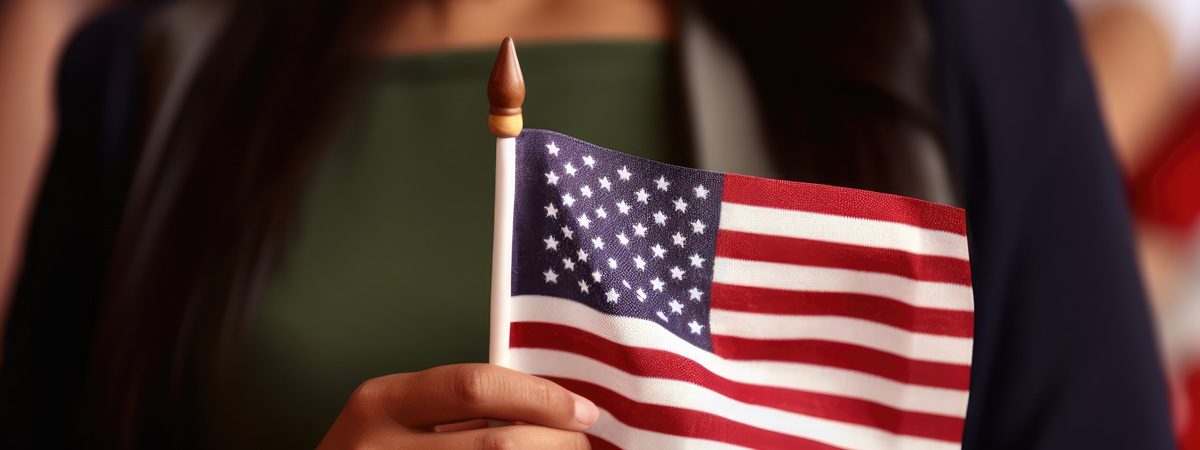A person holding a small American flag in El Paso.