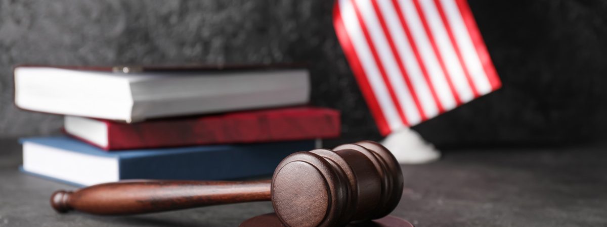 A gavel with the american flag and books in the background in El Paso.