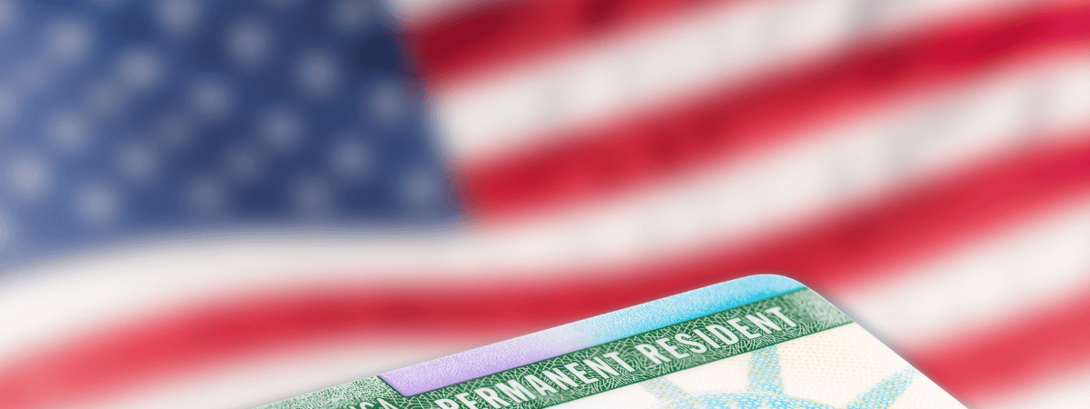 A naturalization card with an American flag in the background